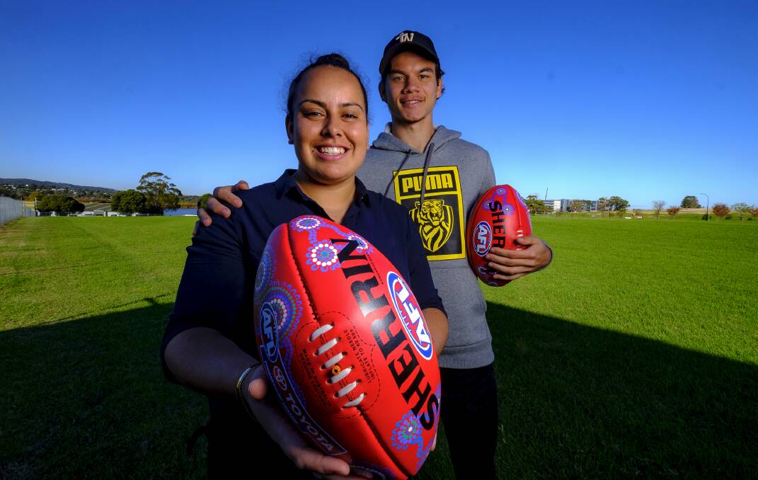 Cronulla artist Rheanna Lotter, with Richmond star Daniel Rioli, at the Sherrin football factory in Scoresby on Wednesday. Picture: Luis Enrique Ascui