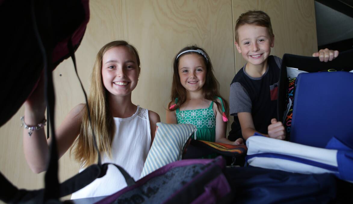 Pack to School: Pack by name, pack by nature. Teyha, Joel and Eva Pack help put backpacks together for disadvantaged children. Picture: John Veage