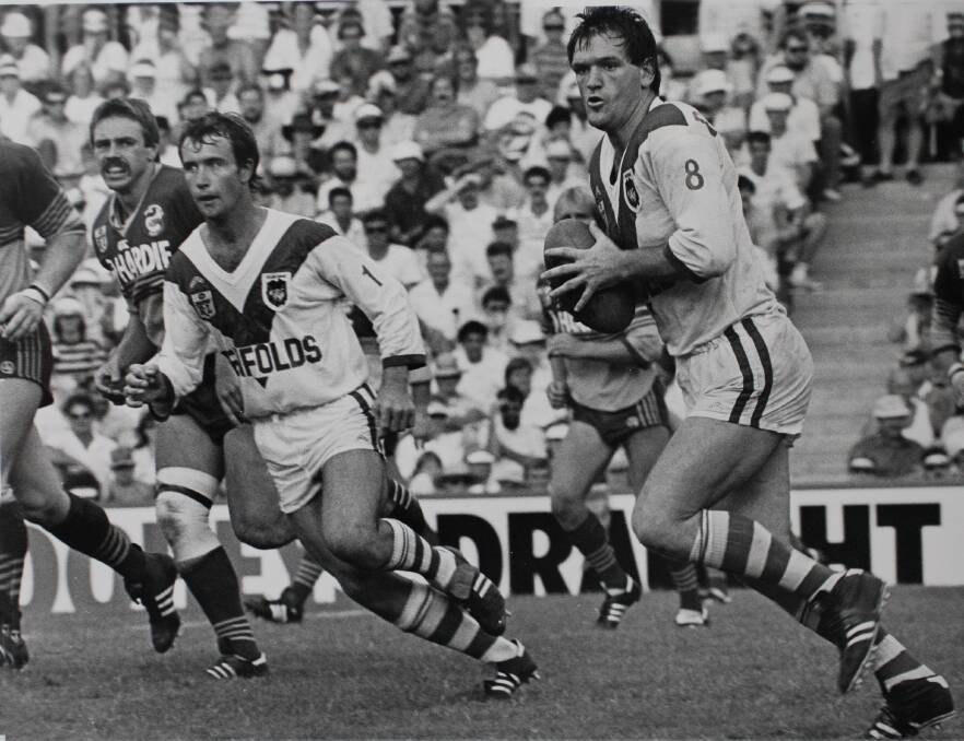 Fullback: Glenn Burgess runs off a rampaging Graeme Wynn playing for St George in the mid 1980's-he was chosen as the Penshurst RSL Kookaburras best no 1. Picture: John Veage