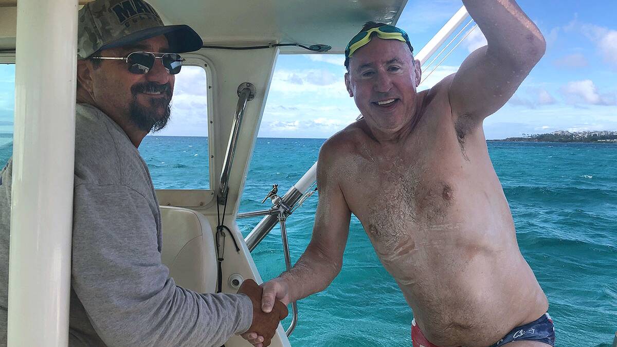 Record: Cronulla's Dr Andrew Davis is congratulated by Skipper Randy Kinores after his crossing of the Au'au Channel last month. Picture: Supplied