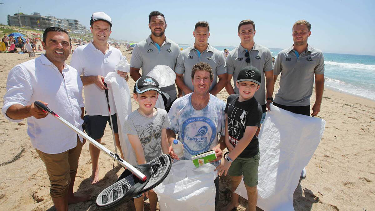 Cleaner: Will and Zane Lowe with their bag of rubbish with Mayor Pesce ,Mark Speakman,Sharks players and Surfriders Joe Glendenning on North Cronulla Beach.Picture John Veage