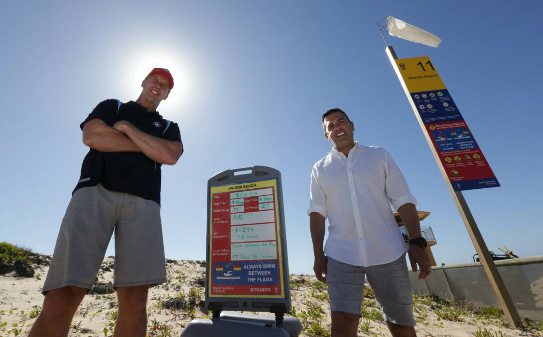 Safety signs: Mayor Carmelo Pesce (right) and Steve Pearce, CEO SLSNSW, at Wanda with new signage that’s been specially designed to avoid language or culture becoming a barrier when it comes to beach safety. Picture: John Veage