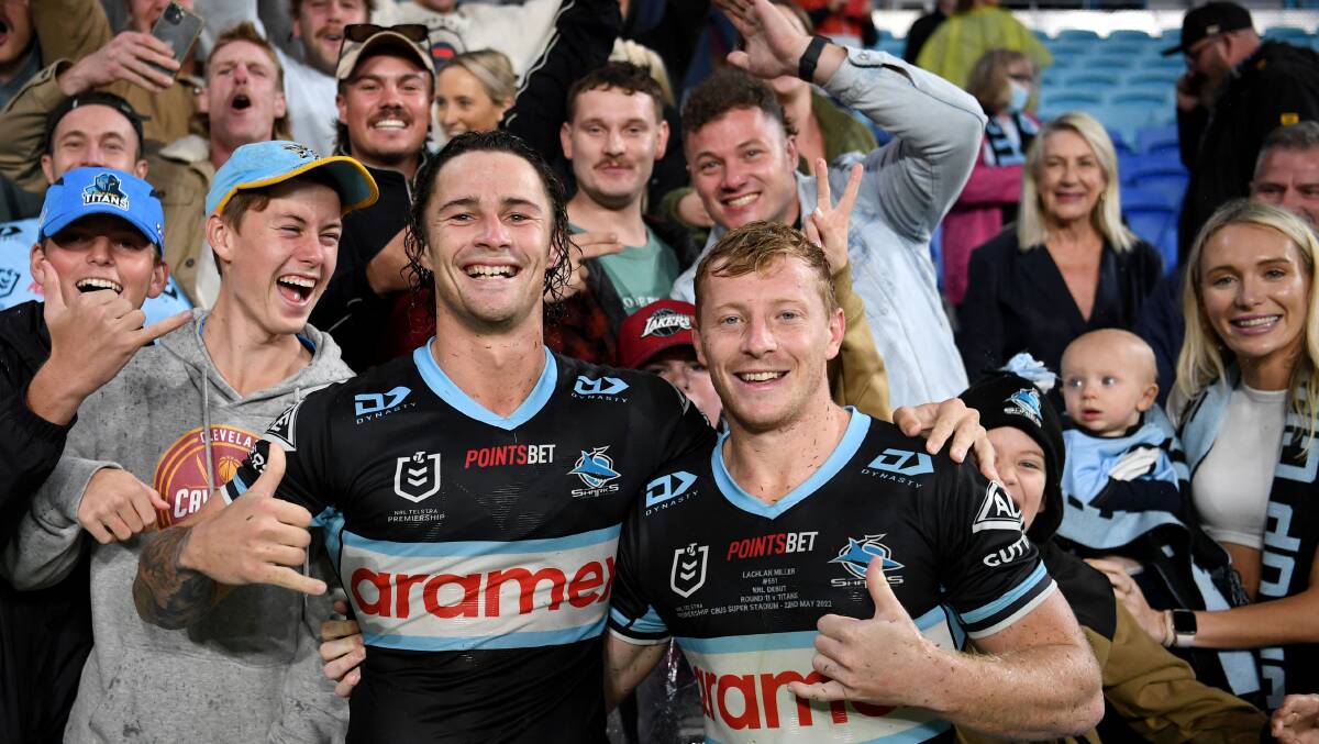 All smiles: Nicho Hynes celebrates with debutant Lachie Miller's friends and family after the Sharks' 25-18 win over the Titans on Sunday. Picture NRL Images