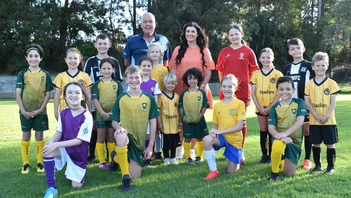 Member for Miranda Eleni Petinos and Sutherland Shire Footballs Matt Brady with junior members of the Associations football clubs