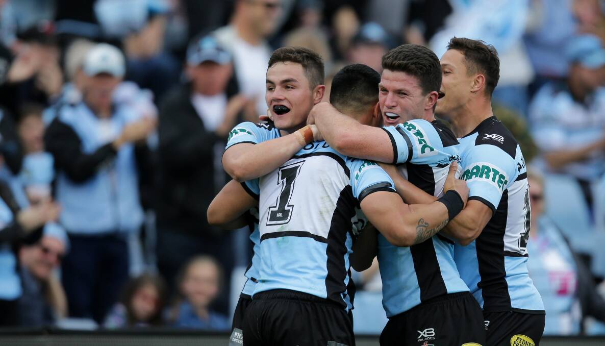 Happy days: Kyle Flanagan celebrates a try with Valentine Holmes during his first grade debut. Picture: John Veage