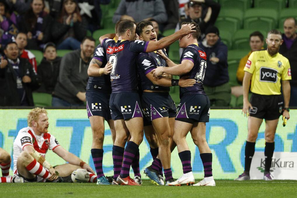Down not out: Dragons forward James Graham watches on as the Storm celebrate a late try. Picture: AAP Image