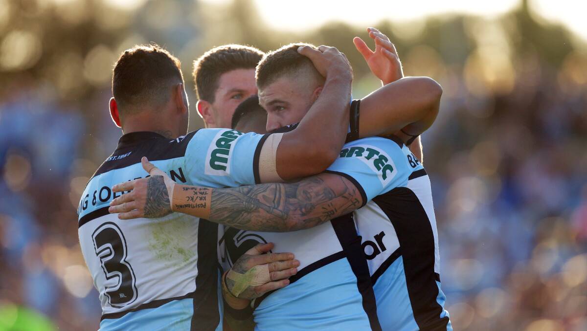 Celebration: Cronulla players are all smiles after a Valentine Holmes try against Penrith. Picture: Chris Lane
