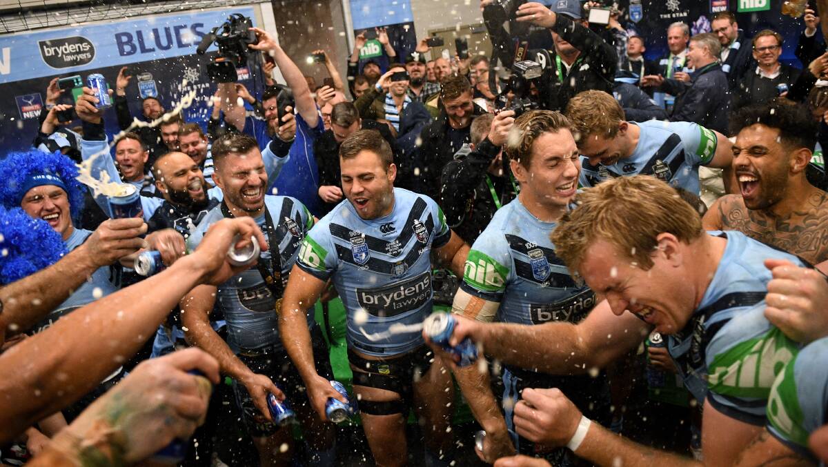 Out, but not down: Wade Graham (centre) celebrates with his NSW teammates after their Origin series victory on Wednesday night. Picture: Dan Himbrechts/AAP Image