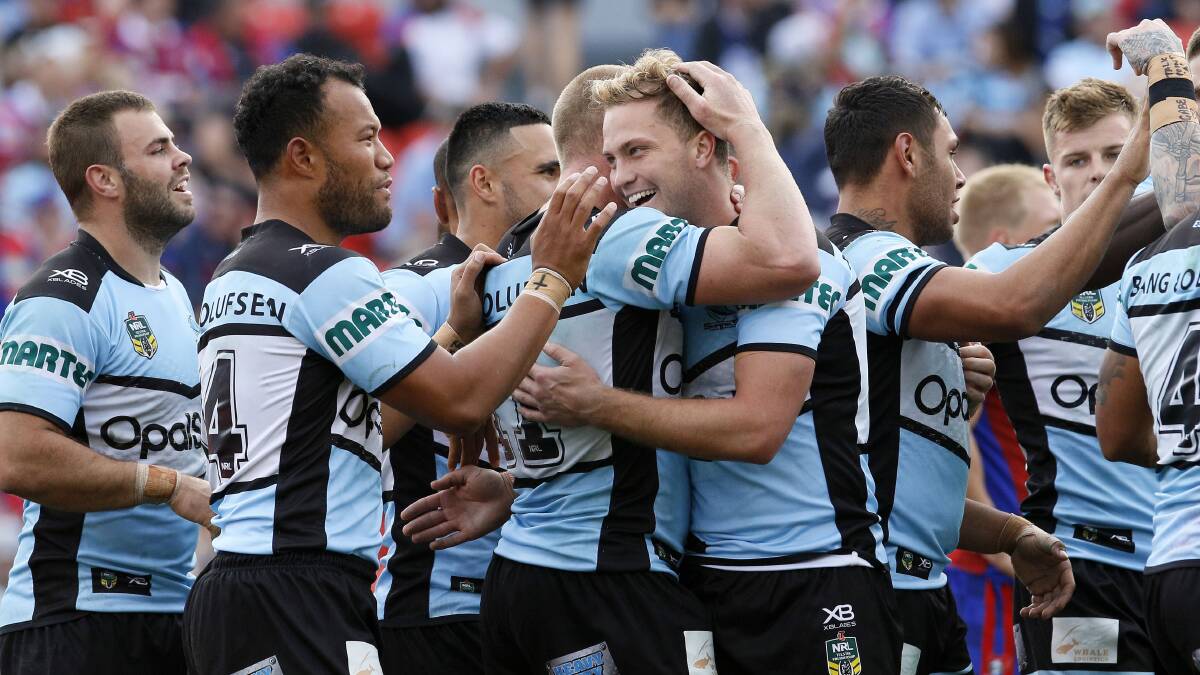 All smiles: Matt Moylan is congratulated by Cronulla teammates after laying on another try against Newcastle on Sunday. Picture: AAP Images