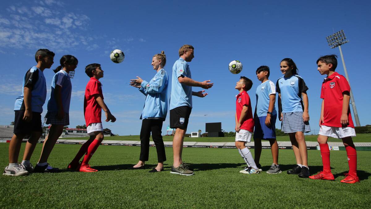 New home: Sydney FC players Ally Green and Rhyan Grant with St George Football Association juniors at Jubilee Oval, Kogarah earlier this year. Picture: John Veage