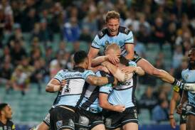 Celebration time: Chad Townsend is congratulated by his Cronulla teammates after scoring the opening try against Penrith. Picture: Chris Lane