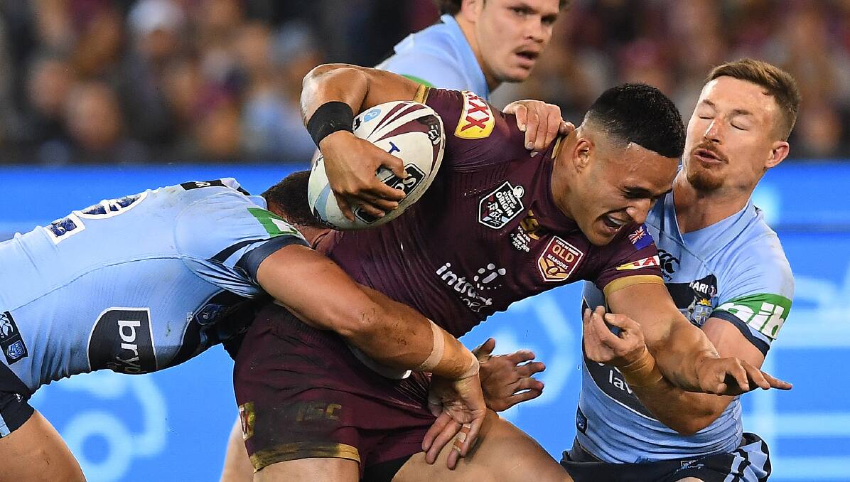 Tough going: Valentine Holmes hits the ball up against NSW. Picture: AAP