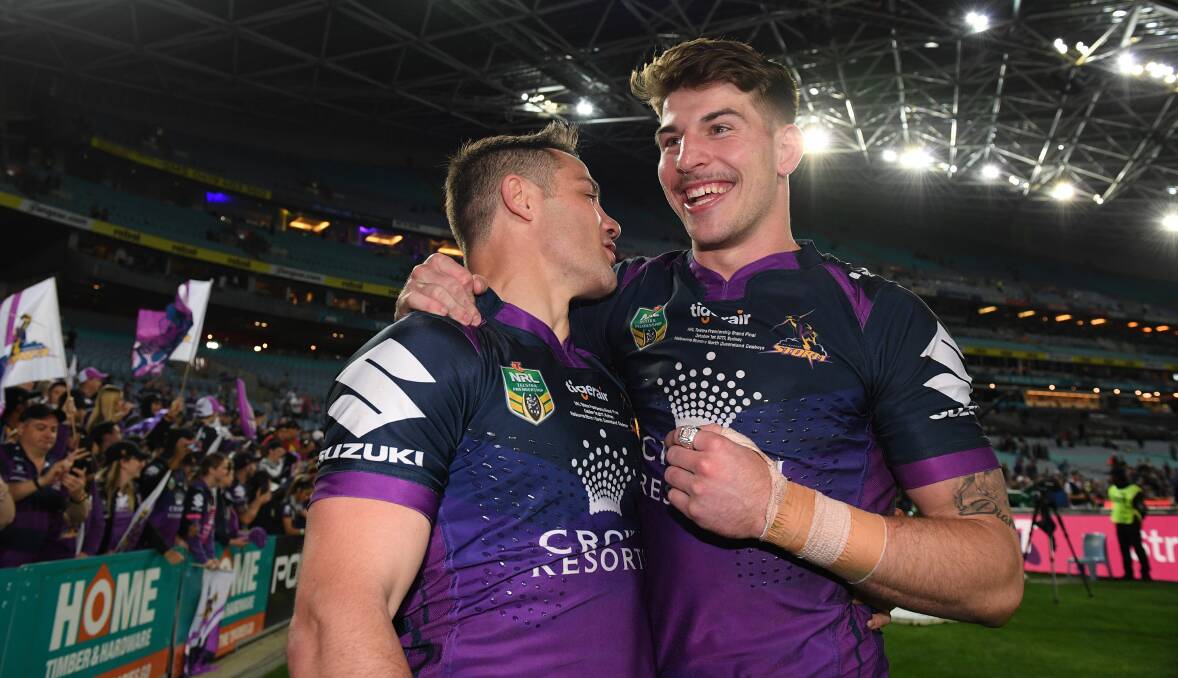 All smiles: Cronulla Sharks junior Curtis Scott (right) celebrates Melbourne's premiership with Storm halfback Cooper Cronk on Sunday night. Picture: AAP Image