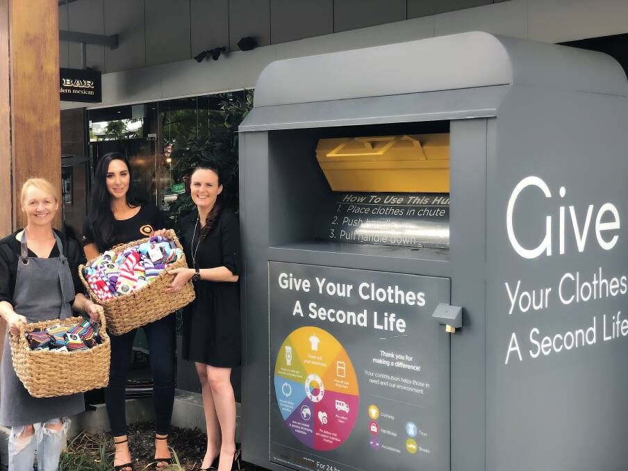 Spring clean: Alexis Todorovski (centre) at one of SCRgroup's clothing and textile donation bins. Picture: SCRgroup