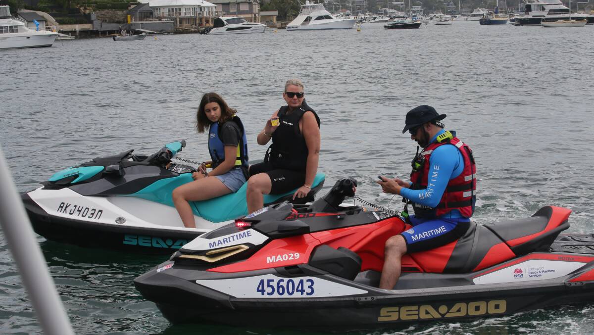 Safety on the water: A NSW Maritime inspector carries out a licence check on Danielle and Zoe Farrugia during operation 'Tow the Line'. The Farrugia's were among those who were behaving responsibly. Picture: John Veage