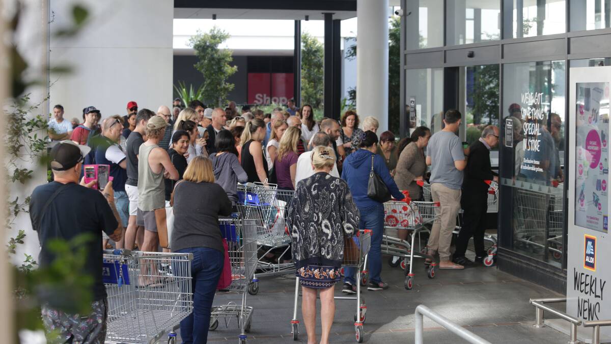 PANIC MERCHANTS: Shoppers queue outside Aldi. Picture: John Veage