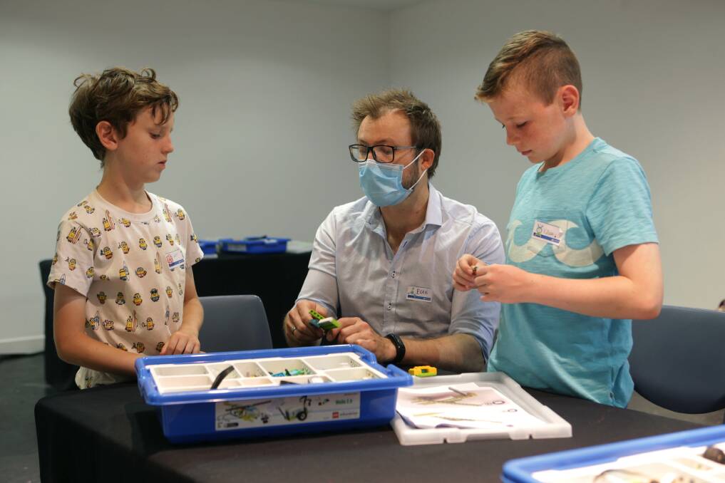 SCIENCE IS FUN: Evan the workshop facilitator and Lachlan and Killian building Lego beyblades. PHOTO: JOHN VEAGE.