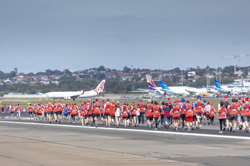 Sea of red: People ran alongside planes for a community event. Picture: Supplied