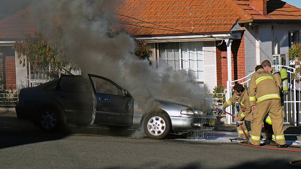 Lucky escape: Firefighters work to put out a car fire at Bexley. Picture: Charlie Straumietis