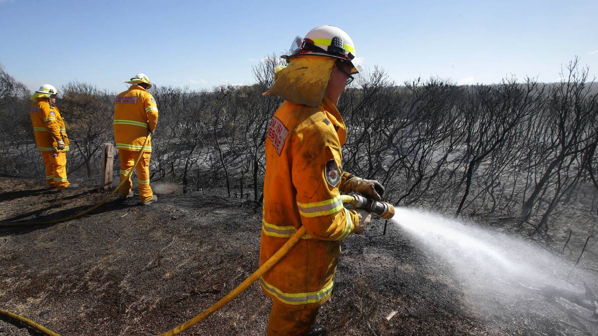 Danger: NSW Rural Fire Service volunteers mop up after a large fire at Kurnell in September. Picture: John Veage