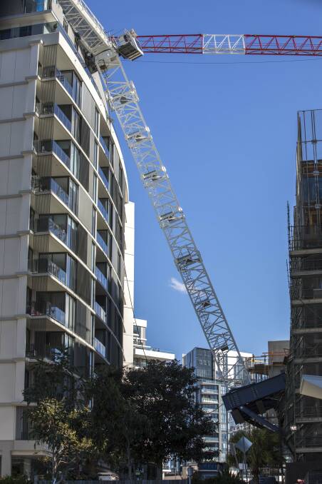 Quick response: A crane was in the process of being set up when it fell backwards, slamming into a nearby penthouse apartment. Picture: Michele Mossop
