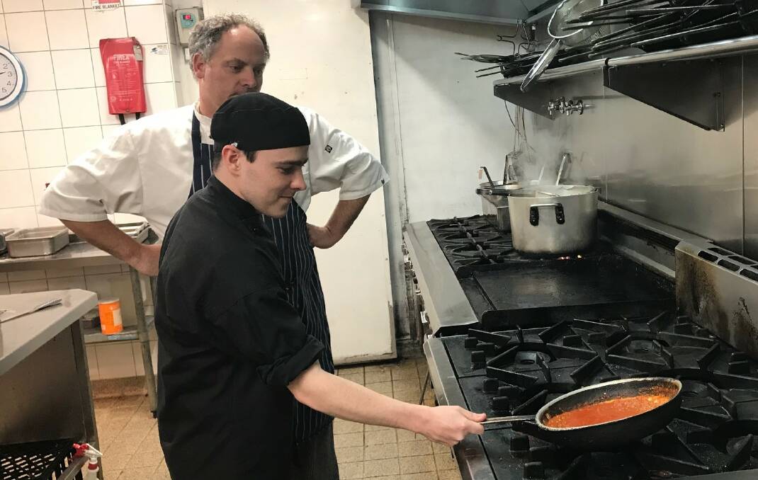 Miranda RSL Executive Chef Andrew Harper giving his apprentice a few pointers in the kitchen. The young man is a worker with a disability.