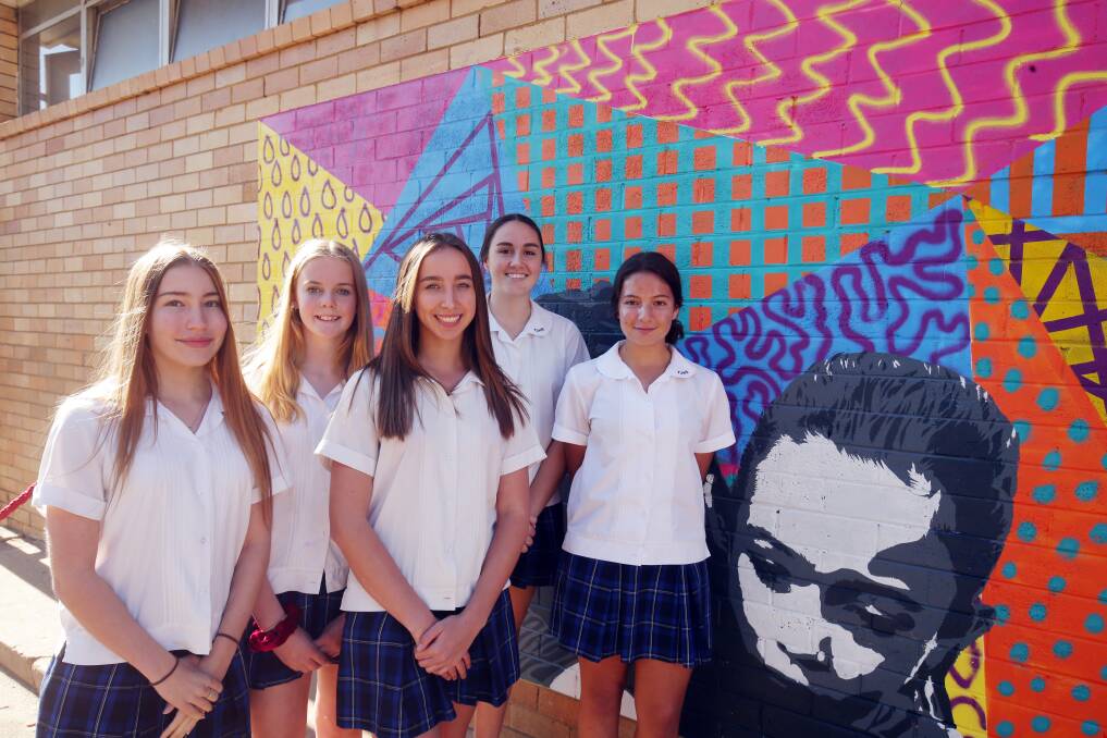 Artistic splash: The Jannali High School students Catherine Graham, Dea Andersen, Natalie Hobson, Annabel Hillier and Daniella Batten and their new mural, unveiled for World Refugee Day. Picture: Chris Lane