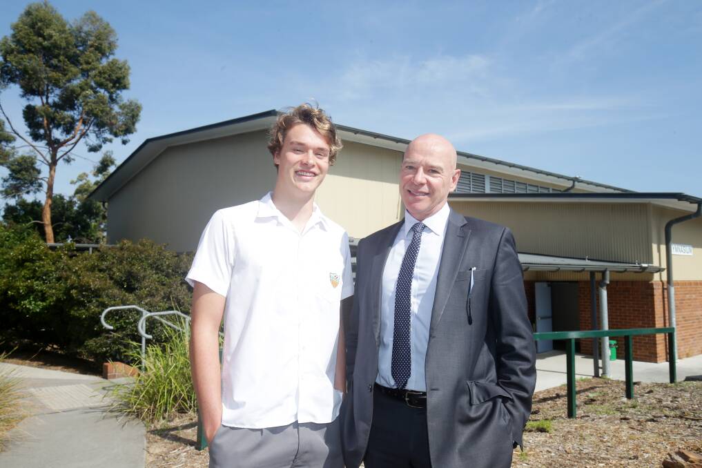 Delivering change: Caringbah High School student Kal Glanznig with principal Alan Maclean outside the school hall that now has solar panels installed - an initiative launched by the student. Picture: Chris Lane