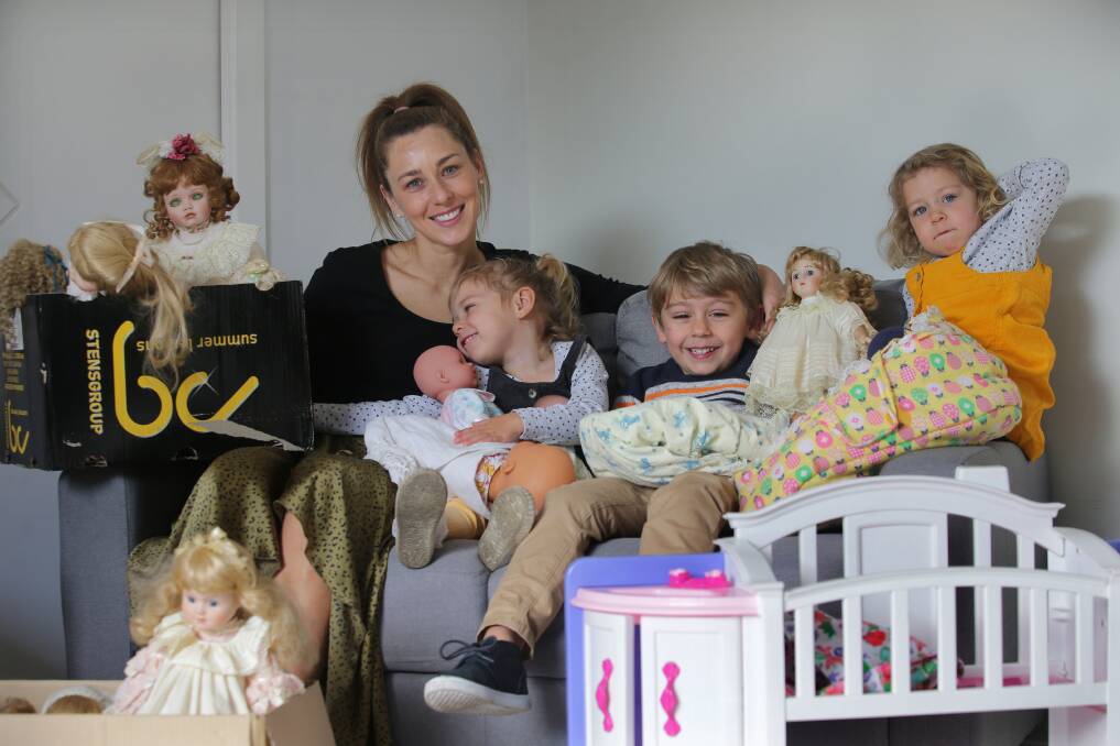 Cuddle therapy: Olivia Peach with children Oscar, 4, and twins Amelia and Willow, 2, with some of the dolls she has collected as part of her nursing home donation drive. Picture: John Veage