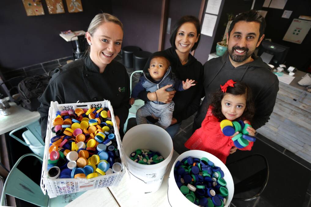 From plastic to fantastic: Jacqui Birss, Pardip and Nathan Pillai with children Samara and Rylan at Bella Cibo Caringbah, which is Sydney's only collection point for a project that turns lids into limbs. Picture: John Veage