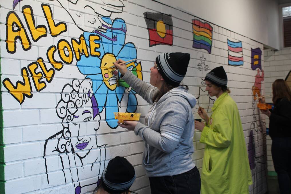 Continuous Lines participants paint a mural.