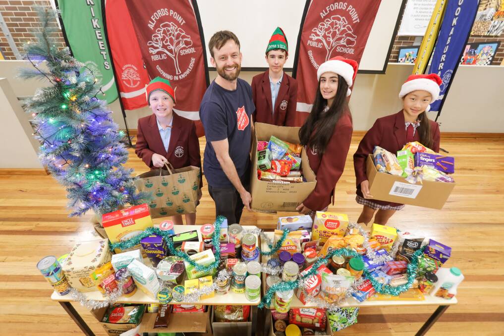 Alfords Point Public School pupils Oliver, Archie, Soukayna and Hannah, with Joel from the Salvation Army, and their large collection, ready to be donated to families in need ahead of Christmas. Picture John Veage