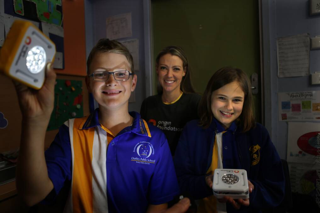 Lighting up: Oatley Public School pupils with Origin Foundation's Michelle Zahra, with their solar-powered lights. Picture: John Veage