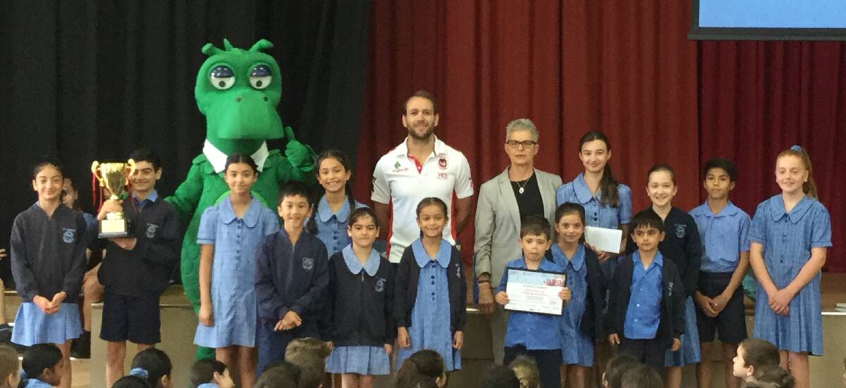 The St George Happy Dragon, chief executive of St George and Sutherland Medical Research Foundation Jacquie Stratford and Jason Nightingale present the winning 'dash' school to St Patrick's Kogarah.