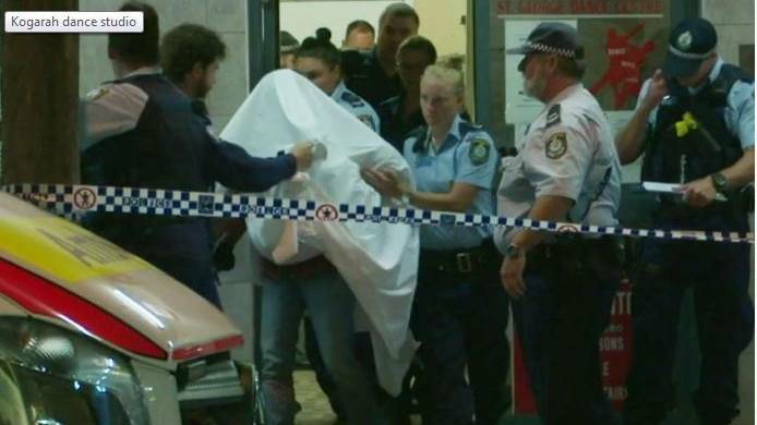 A man is escored from the dance centre at Kogarah after a girl, 7, was allegedly sexually assaulted. Picture: ABC