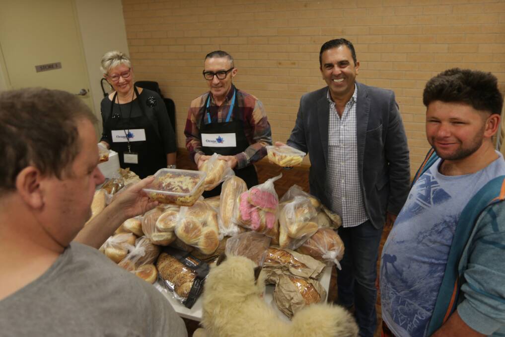 Breakfast drive: Sutherland mayor Carmelo Pesce helps with handing out free bread at Orana Hub Central, Sutherland. Picture: John Veage
