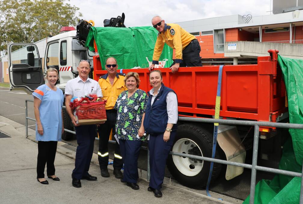 Generous cargo: Sutherland Hospital staff hand over donations to Sutherland Rural Fire Service firefighters, who will take the goods to farmers ahead of Christmas. ​Pictured: Maggie White, John Witherden, Anthony Gray (RFS), Rebecca Kelly, Candice Fogarty and Richard Soar (RFS).
