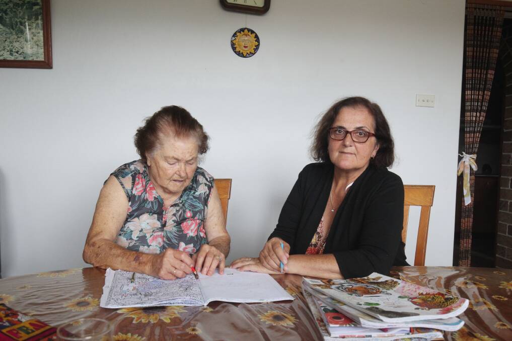 Maria enjoys one of her favourite activities, colouring, with her daughter Carol by her side. Picture by Chris Lane