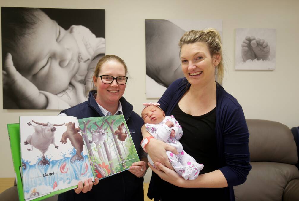 Books for bubs: Nurse Tina Burtenshaw and new mum Melissa Delaney with baby Dakota. Picture: Chris Lane
