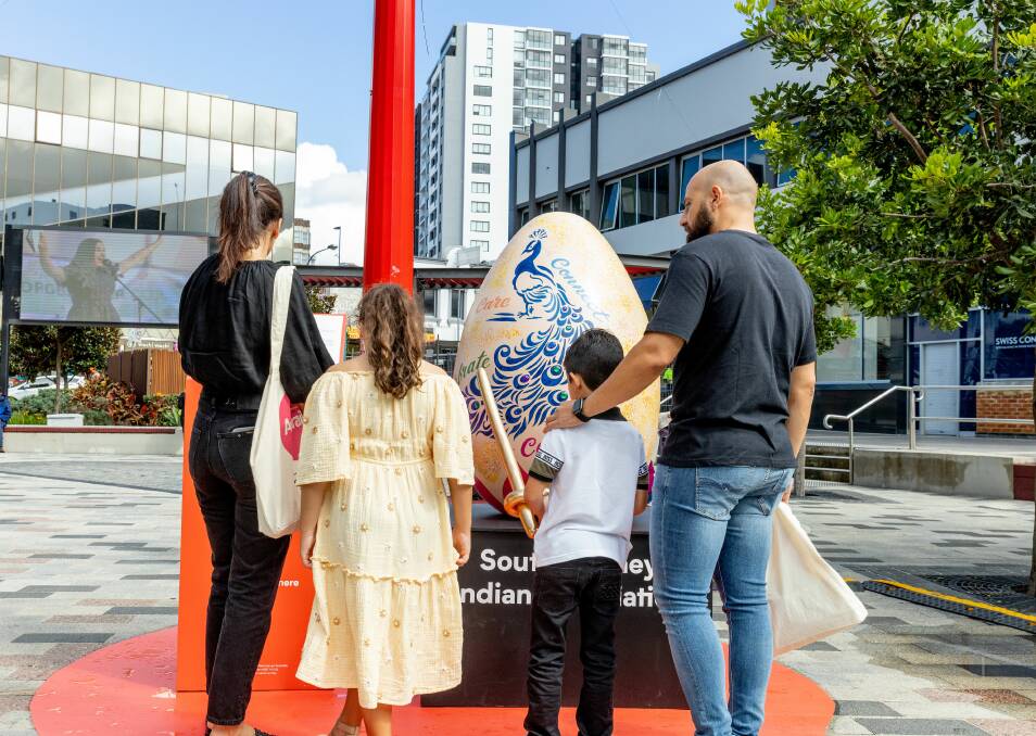 Symbolic creation: Sue Ellan Vasiliou and her family at Westfield Hurstville with a giant egg that was designed using their late daughter's drawings. 
