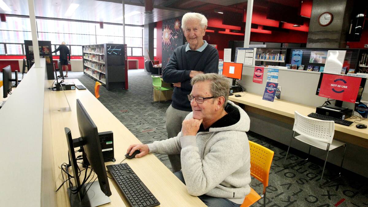 Book worms: Mark (sitting) and Barry Chigwidden are happy to be back in Cronulla library. Pictures: Chris Lane