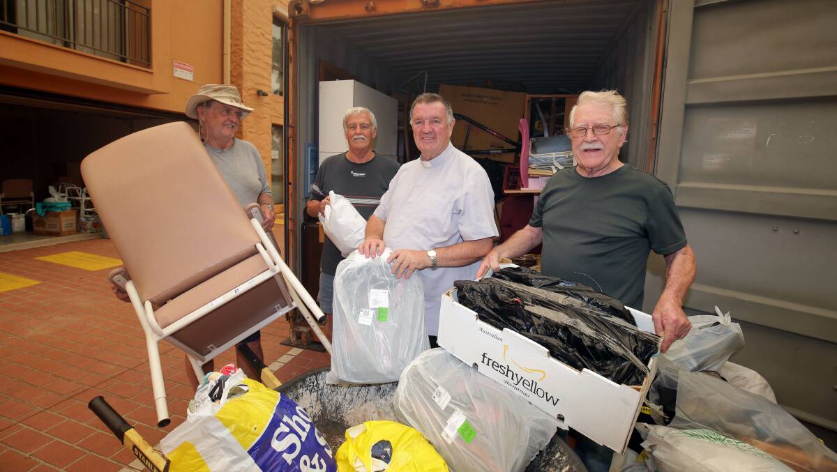 Barry Elliott, Bernie Brennan, Monsignor Brian Rayner and Peter McGrath load goods into a container. Picture: Chris Lane