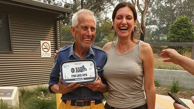 Breathing easy: Ophelia Haragli presents a mask to RFS volunteer John this week. Picture: Supplied.
