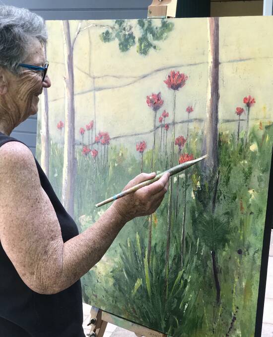 Colour on canvas: Artist Lynn Christie puts the finishing touches to her artwork of Gymea lilies.