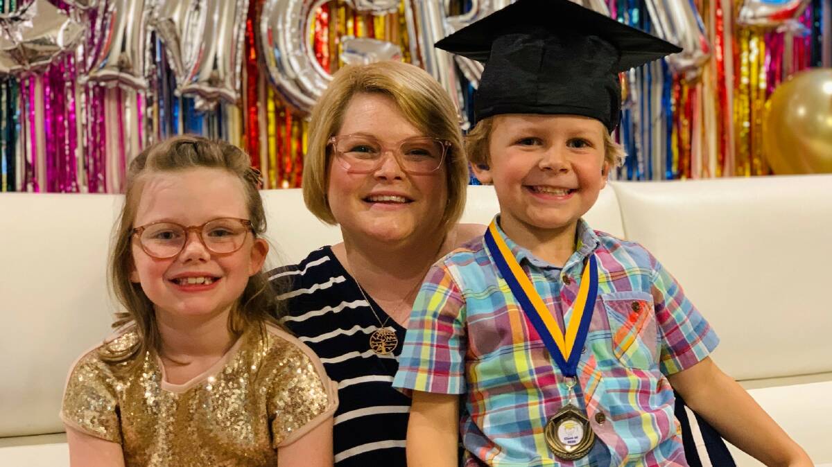Hearing help: Lachlan Sorensen at his 'graduation' with mum Jessica and sister Hannah. Picture: Supplied