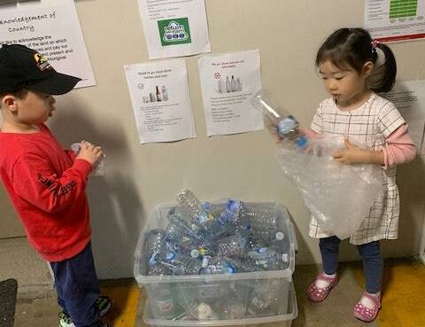 Little earner: Preschoolers James and Shuyan sort the empty bottles at the childcare centre. Picture: Supplied
