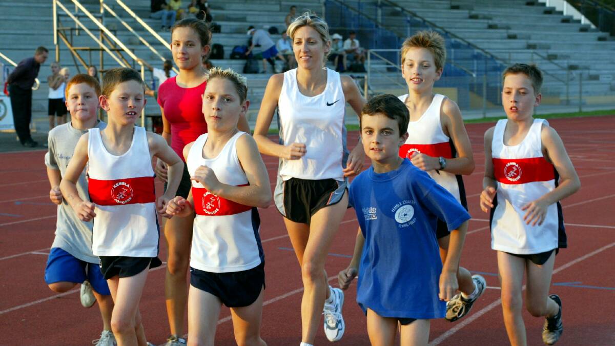 Community focus: Kerryn McCann (centre) runs with a number of Kembla Joggers juniors in 2003. Picture: Ken Robertson.