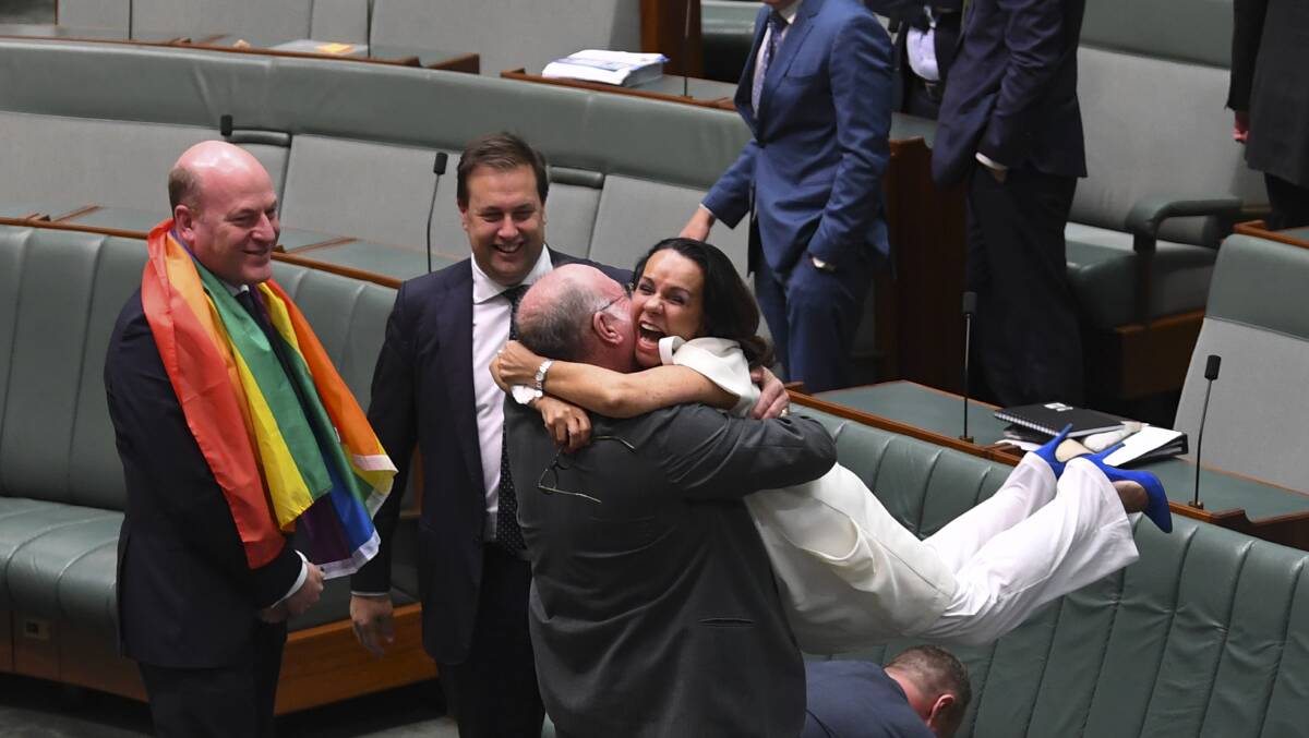 Exuberant: Liberal MP Warren Entsch lifts up Member for Barton Linda Burney as they celebrate the passing of the Marriage Amendment Bill. Picture: AAP/Lukas Coch