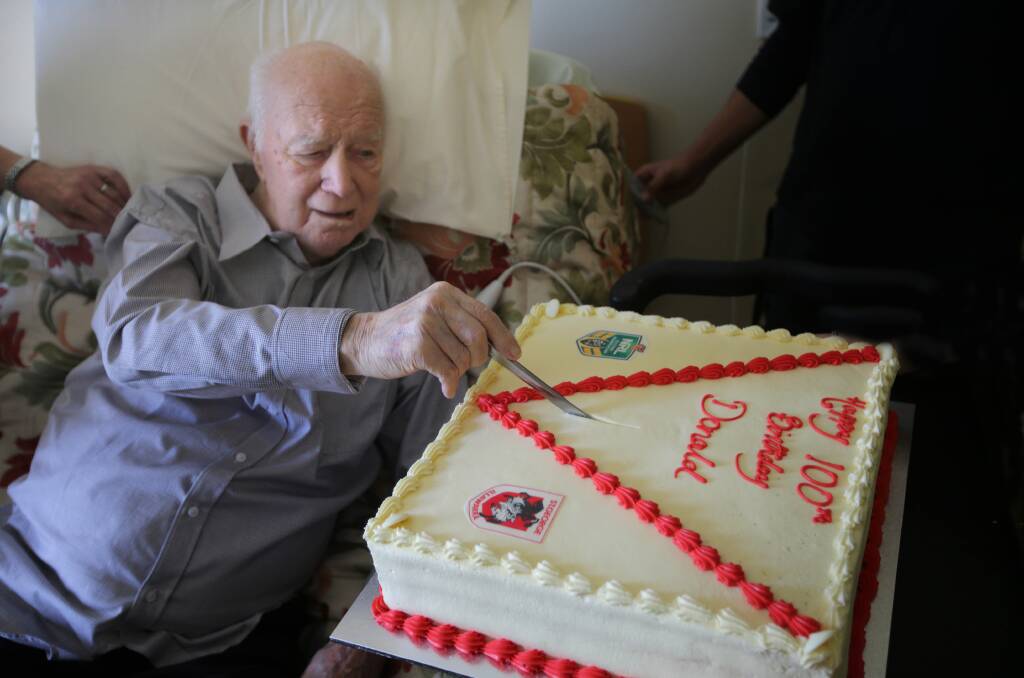 Lifetime supporter: Donald Patterson cuts his Dragons theme birthday cake as his celebrates his 100th birthday. Picture: John Veage