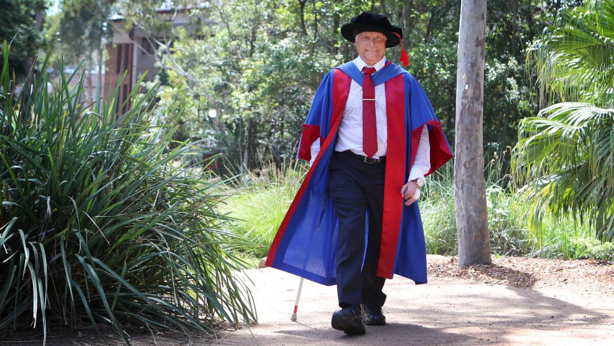 Dr Robert Sawyer lost three of his mates and his eyesight in his former life as a volunteer fire fighter. On Wednesday he graduated from the University of Wollongong. Picture: Sylvia Liber
